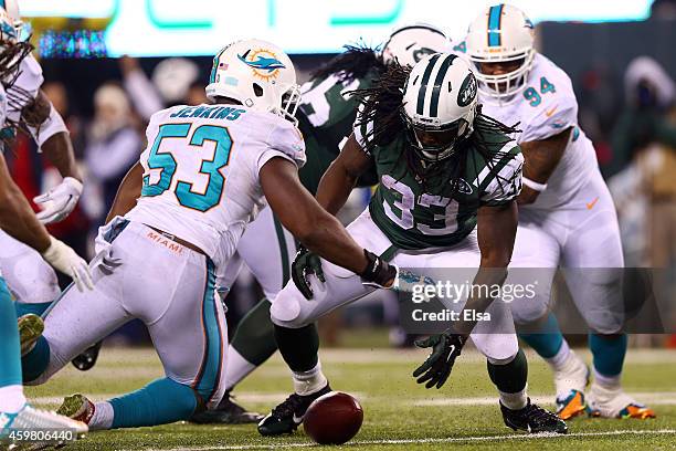 Chris Ivory of the New York Jets recovers a fumble by Geno Smith against Jelani Jenkins of the Miami Dolphins in the fourth quarter during their game...