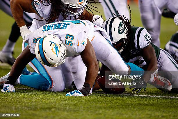 Chris Ivory of the New York Jets recovers a fumble by Geno Smith against Jelani Jenkins of the Miami Dolphins in the fourth quarter during their game...