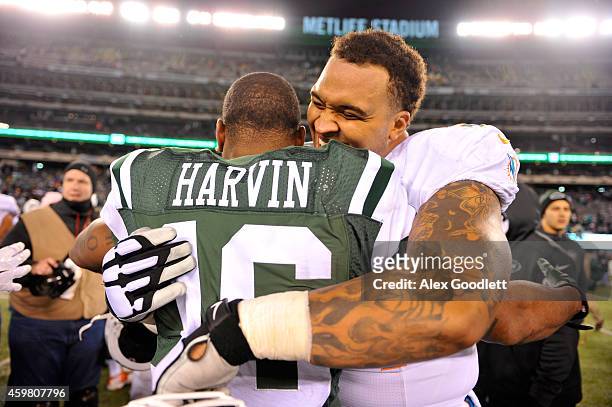 Mike Pouncey of the Miami Dolphins hugs Percy Harvin of the New York Jets after their game at MetLife Stadium on December 1, 2014 in East Rutherford,...