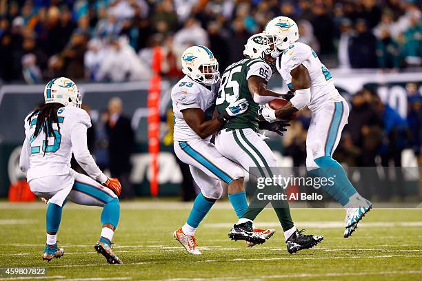 Reshad Jones of the Miami Dolphins intercepts a ball intended for Jeff Cumberland of the New York Jets late in the fourth quarter during their game...