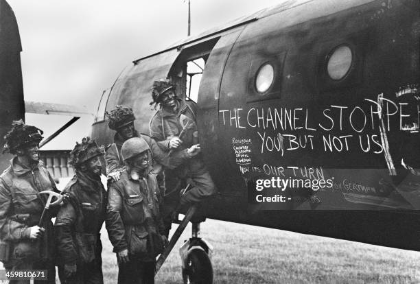 British paratroopers in their war paint read slogans chalked on a glider plane in June 1944, after Allied forces stormed the Normandy beaches during...