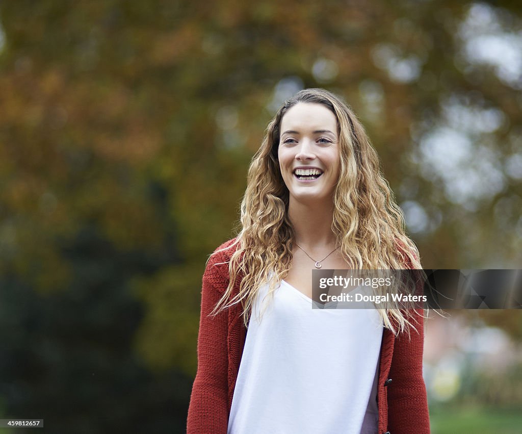 Woman laughing in Autumn park.