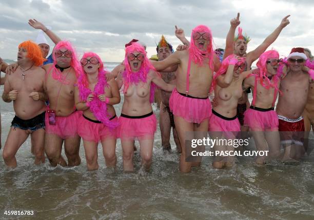 People take part in a traditional sea bathing to mark new-year's end on December 31, 2013 on a nudist beach in Le Cap d'Agde, southern France. AFP...