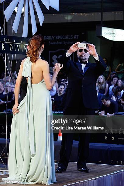 Olga Kurylenko and Russell Crowe arrive on stage during the World Premier of "The Water Diviner" at the State Theatre on December 2, 2014 in Sydney,...