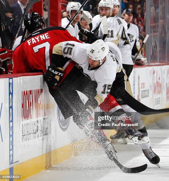 Tanner Glass of the Pittsburgh Penguins checks Mark Fayne of the New Jersey Devils into the boards during the second period of an NHL hockey game at...