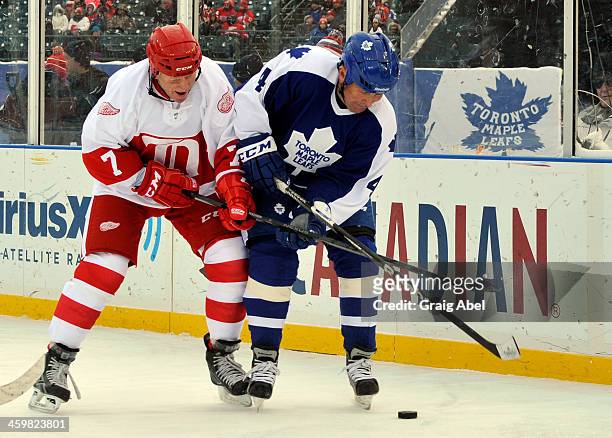 Mike Pelyk of the Toronto Maple Leafs Alumni battles for puck against Red Berenson of the Detroit Red Wings Alumni during game action on December 31,...