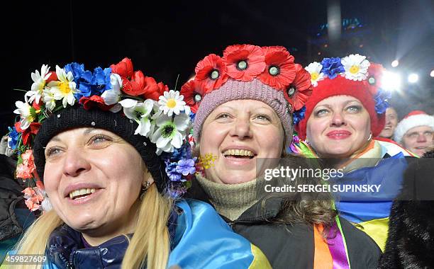 Ukrainian women wearing traditional wreathes dance and sing during a mass demonstration marking the approaching New Year on Independence Square in...