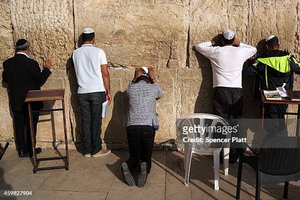 Men pray at the Western Wall in the Old City on December 02, 2014 in Jerusalem, Israel. As violence continues in Israel, an Israeli was stabbed and...