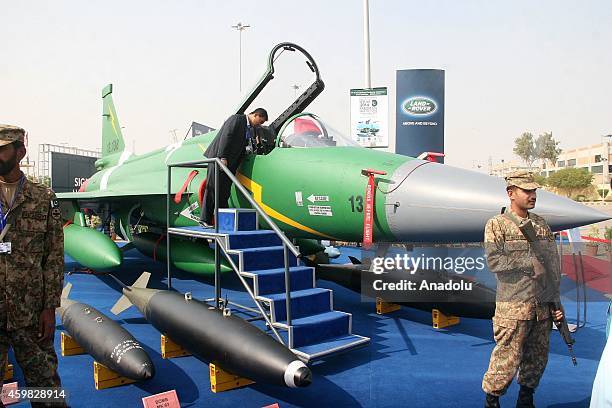 People gather around Pakistan and China's jointly developed PAC JF-17 Thunder aircraft during the International Defence Exhibition and seminar in...