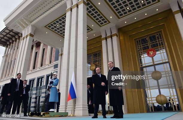 Turkish President Recep Tayyip Erdogan shakes hands with Russian President Vladimir Putin at the entrance of Turkey's Presidential Palace in Ankara,...