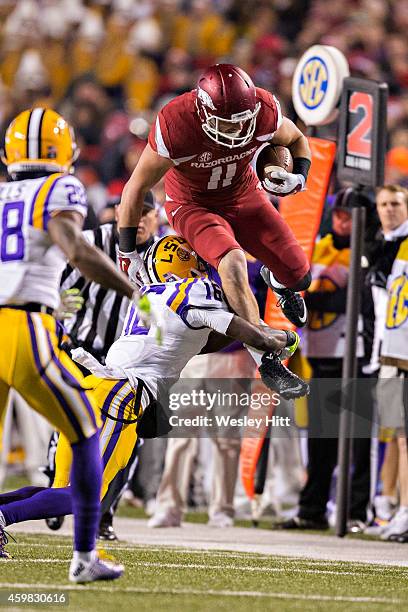 Derby of the Arkansas Razorbacks jumps over Tre'Davious White of the LSU Tigers during the second quarter at Razorback Stadium on November 15, 2014...
