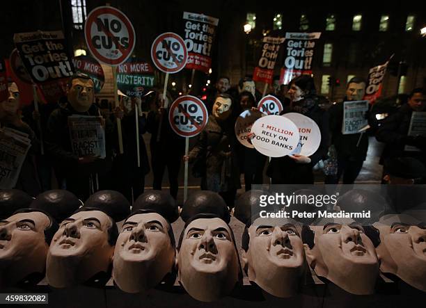 Masks depicting Chancellor of the Exchequer George Osborne are lined up on a wall opposite Downing Street by anti austerity protestors on December 2,...