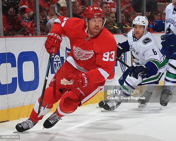 Johan Franzen of the Detroit Red Wings turns up ice against the in front of Yannick Weber of the Vancouver Canucks during a NHL game on November 30,...