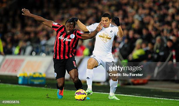 Swansea player Jefferson Montero is challenged by QPR player Nedum Onuoha during the Barclays Premier League match between Swansea City and Queens...
