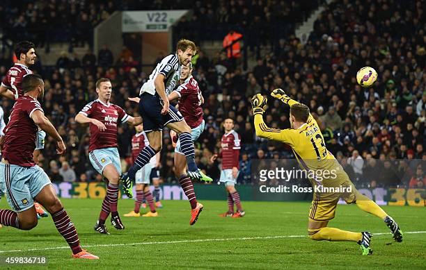Craig Dawson of West Brom heads and scores the opening goal past Adrian of West Ham during the Barclays Premier League match between West Bromwich...