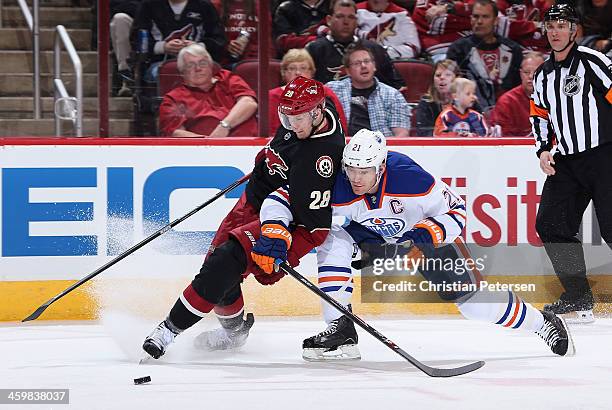 Lauri Korpikoski of the Phoenix Coyotes and Andrew Ference of the Edmonton Oilers battle for a loose puck during the first period of the NHL game at...