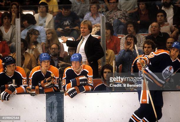 Head coach Glen Sather, Mark Messier and Wayne Gretzky of the Edmonton Oilers look on from the bench during an NHL game against the New York...