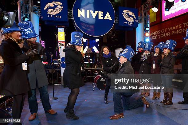 Zac Hihey surprises his girlfriend, Hannah Kanaan, with a proposal on the NIVEA Kiss Stage in Times Square on December 31, 2013 in New York City.