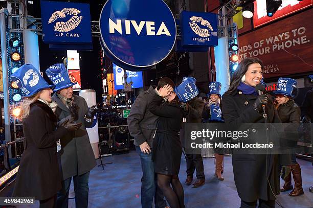 Zac Hihey surprises his girlfriend, Hannah Kanaan, with a proposal on the NIVEA Kiss Stage in Times Square on December 31, 2013 in New York City.