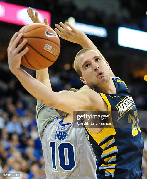 Jake Thomas of the Marquette Golden Eagles grabs a rebound over Grant Gibbs of the Creighton Bluejays during their game at the CenturyLink Center on...