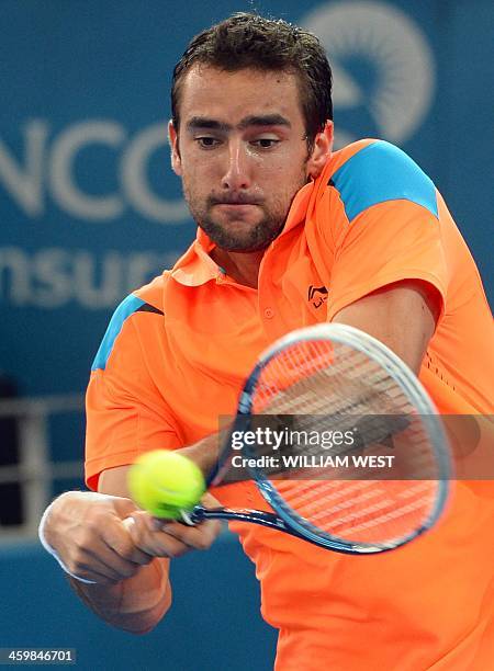 Marin Cilic of Croatia hits a backhand return during his victory over Grigor Dimitrov of Bulgaria at the Brisbane International tennis tournament, in...