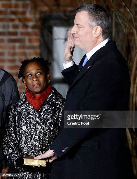 Bill de Blasio is sworn in as the mayor of New York City while his wife Chirlane McCray holds the bible after midnight January 1, 2014 in the Park...