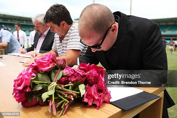 Mourners pay their respects as people gather to watch the funeral service held in Macksville for Australian cricketer Phillip Hughes at the Sydney...