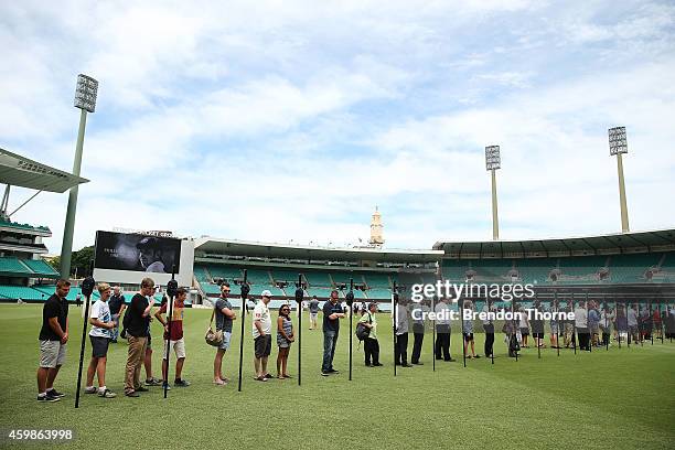 Mourners pay their respects as people gather to watch the funeral service held in Macksville for Australian cricketer Phillip Hughes at the Sydney...