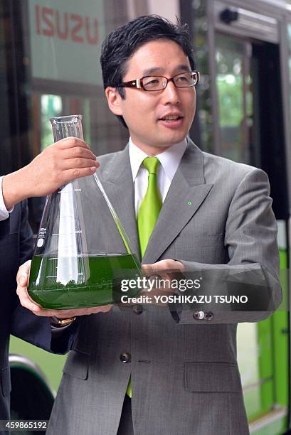 This picture taken on June 25, 2014 shows Japanese biotechnology venture Euglena president Mitsuru Izumo holding euglena in a flask in Tokyo as...