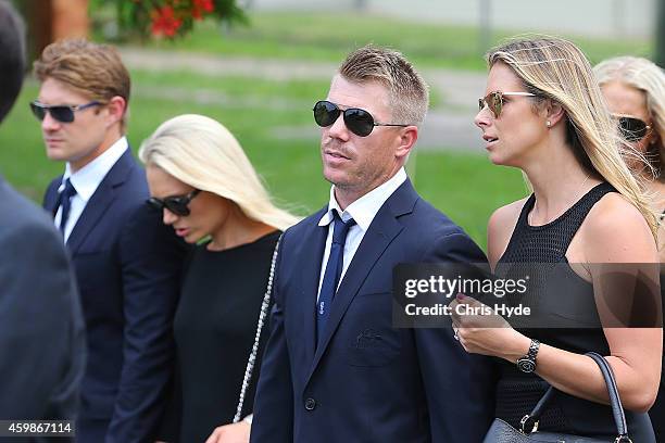 Shane Watson and wife Lee Furlong and David Warner and fiancee Candice Falzon walk in the funeral procession down Wallace Street Macksville after the...