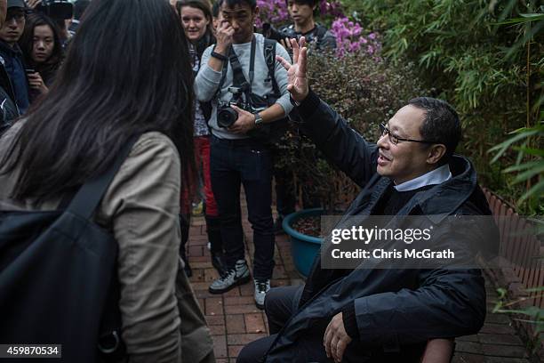 Benny Tai, one of the original pro-democracy Occupy Central founders waves to the media after surrendering to police on December 3, 2014 in Hong...