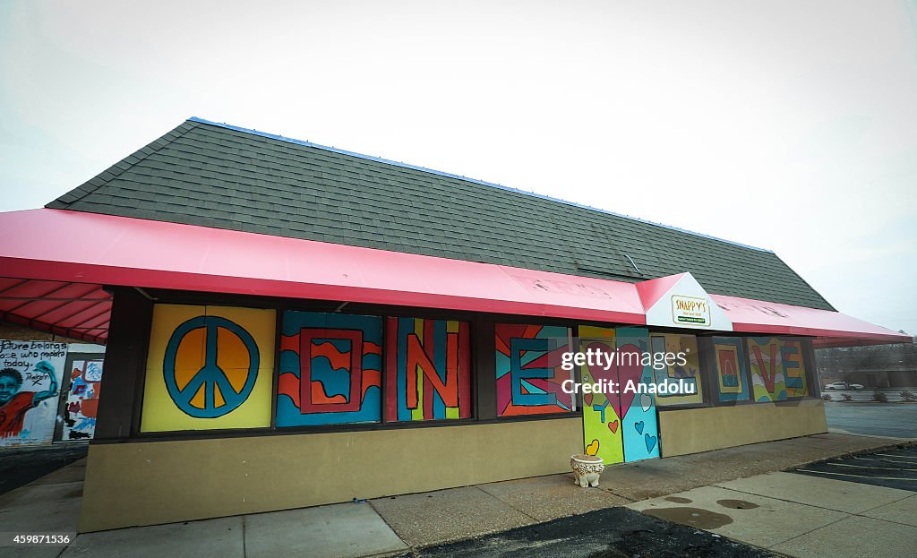 Protestors draw graffiti on the walls of shops in Ferguson