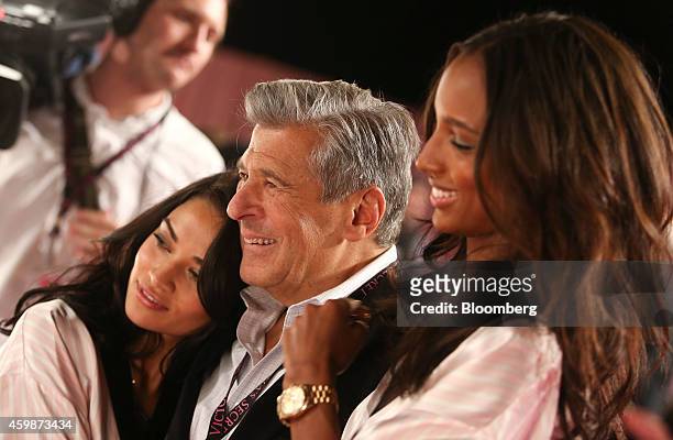 Ed Razek, chief marketing officer of L Brands Inc., center, hugs Kelly Gale, left, and Jasmine Tookes, right, both Victoria's Secret angels, during a...