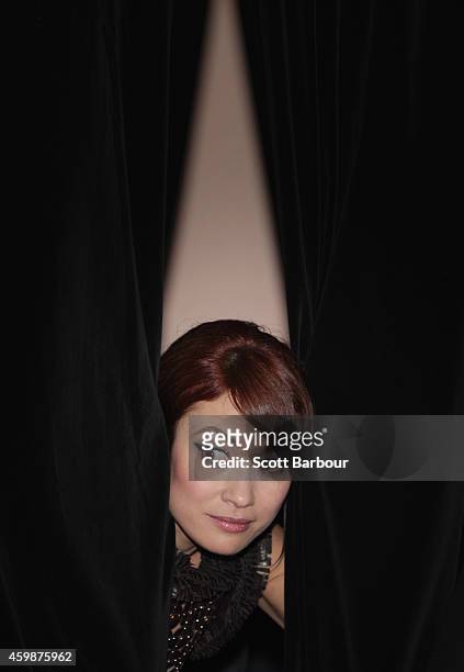Olga Kurylenko peers out from behind a curtain as she waits for Russell Crowe to arrive at the Melbourne Premier of "The Water Diviner" at Rivoli...