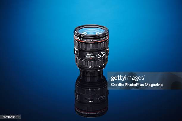 Canon EF 24-70mm f/4L IS USM standard zoom lens photographed on a blue background, taken on December 19, 2013.