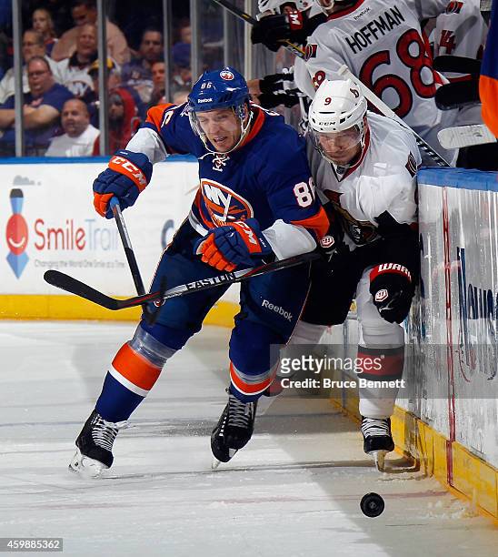 Nikolay Kulemin of the New York Islanders hits Milan Michalek of the Ottawa Senators at the Nassau Veterans Memorial Coliseum on December 2, 2014 in...