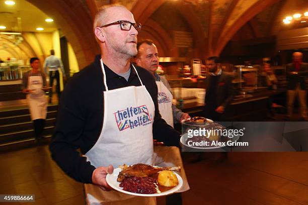Head coach Thomas Schaaf of Eintracht Frankfurt serves food during the christmas goose lunch for homeless people at Ratskeller on December 3, 2014 in...