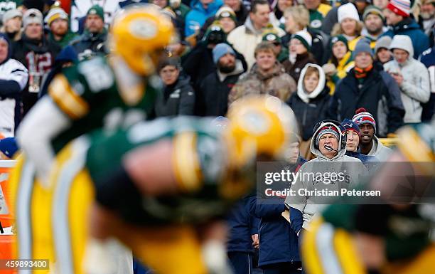 Head coach Bill Belichick of the New England Patriots looks on as quarterback Aaron Rodgers of the Green Bay Packers snaps the football during the...