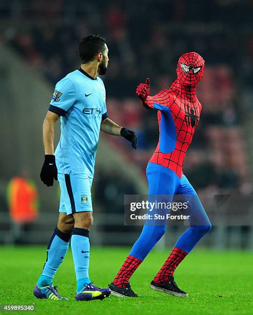 Spectator dressed as Spiderman approaches Manchester City player Gael Clichy during the Barclays Premier League match between Sunderland and...