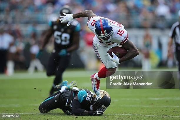 Wide receiver Kevin Ogletree of the New York Giants gets tripped up by safety Sherrod Martin of the Jacksonville Jaguars during an NFL football game...