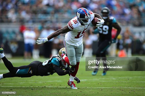 Wide receiver Kevin Ogletree of the New York Giants gets tripped up by safety Sherrod Martin of the Jacksonville Jaguars during an NFL football game...