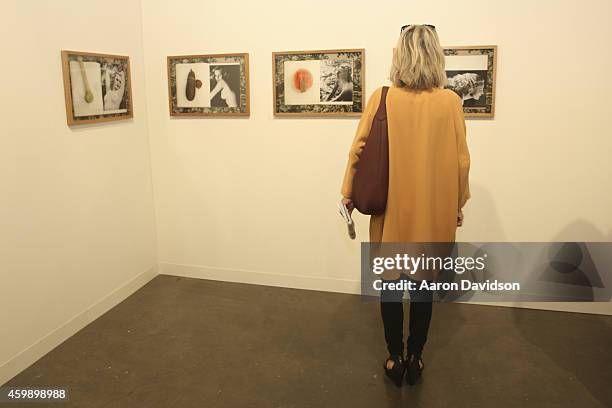 Attendees view art from the Central Galeria de Arte from Sao Paulo during Art Basel Miami Beach 2014 - VIP Preview at the Miami Beach Convention...