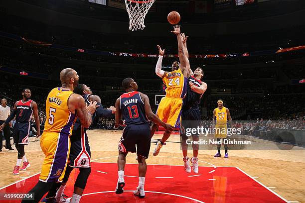 Kobe Bryant of the Los Angeles Lakers shoots against Kris Humphries and Kevin Seraphin of the Washington Wizards during a game at the Verizon Center...