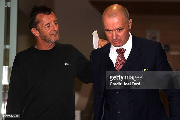 Drummer Phil Rudd leaves Tauranga District Court with lawyer Craig Tuck after being arrested in relation to breach of bail conditions on December 4,...