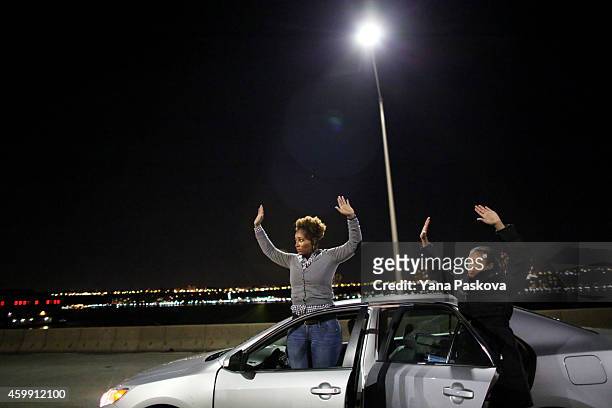 Protesters raise their hands to police on the West Side Highway December 3, 2014 in New York. Protests began after a Grand Jury decided to not indict...
