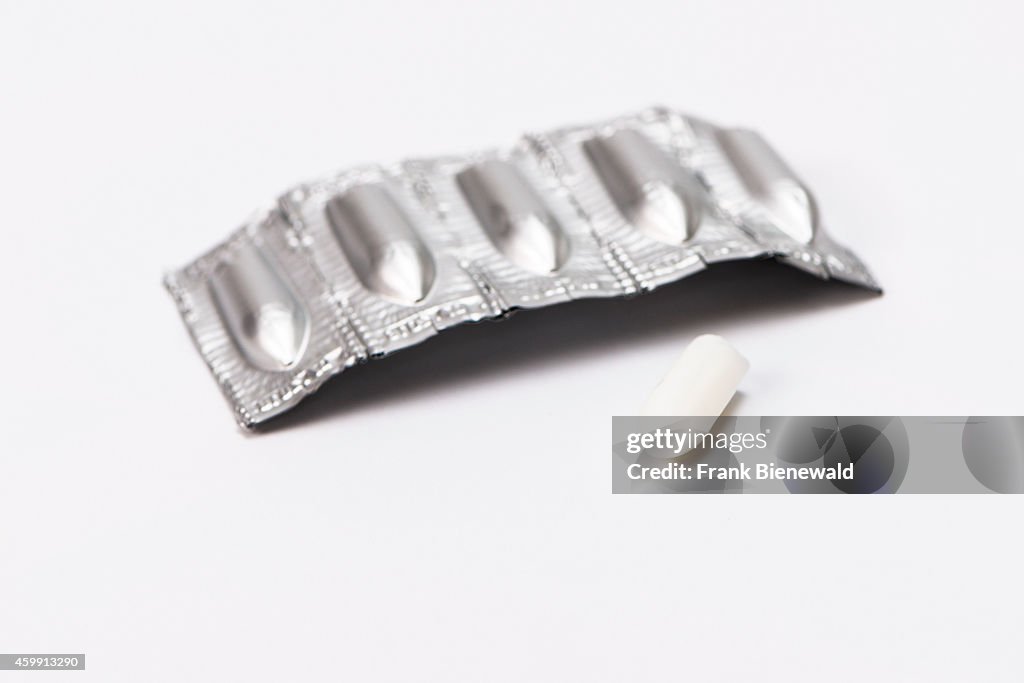 A silverish package with medicine suppository, one unpacked...