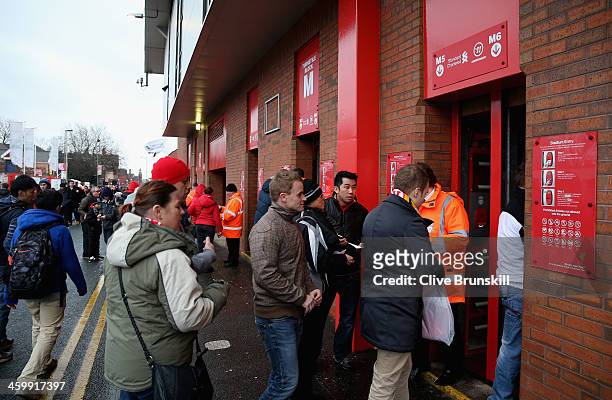 Liverpool fans queue at the turnstiles prior to the Barclays Premier League match between Liverpool and Hull City at Anfield on January 1, 2014 in...