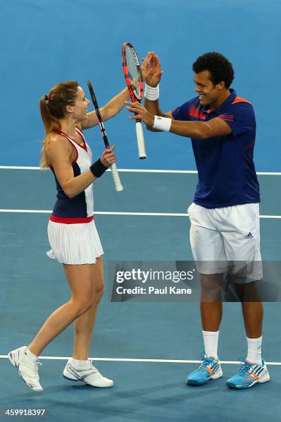 Alize Cornet and Jo-Wilfried Tsonga of France celebrate defeating Sloane Stephens and John Isner of the United States in the mixed doubles match...