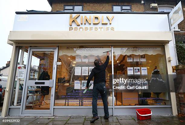 Man cleans the windows of an estate agents on December 4, 2014 in in East Dulwich, London, England. In his autumn statement, Chancellor of the...