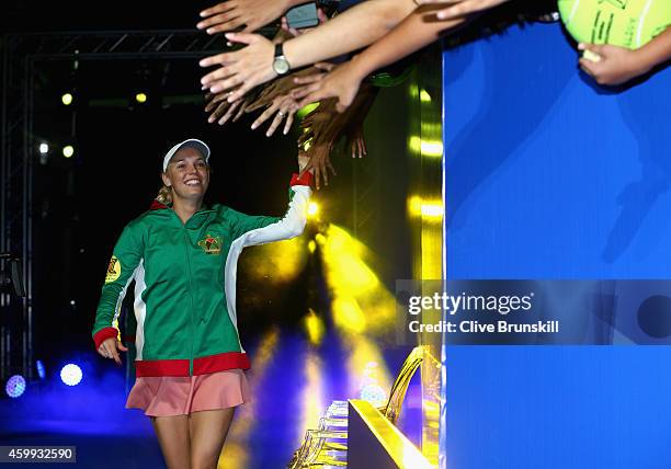 Caroline Wozniacki of the UAE Royals high fives the fans as she runs out for her teams match against the Singapore Slammers during the Coca-Cola...